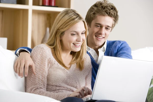 Молодая пара использует ноутбук дома — стоковое фото