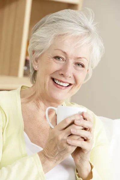 Äldre kvinna njuter av varm dryck — Stockfoto