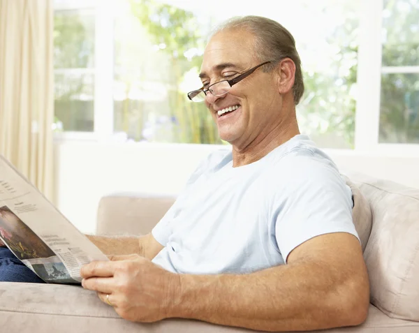 Ανώτερος άνθρωπος διαβάζει εφημερίδα στο σπίτι — Φωτογραφία Αρχείου