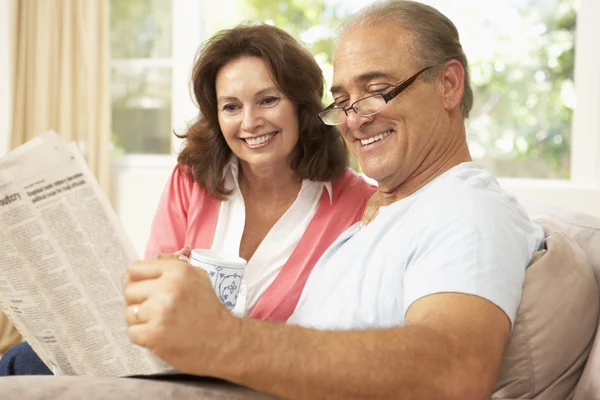 Äldre par läser tidningen hemma — Stockfoto
