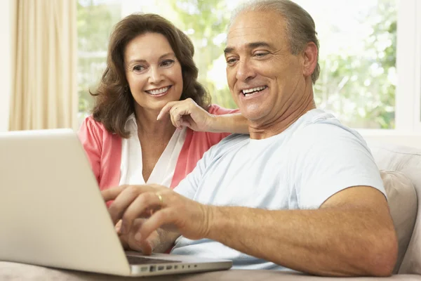 Pareja de ancianos utilizando el ordenador portátil en casa — Foto de Stock