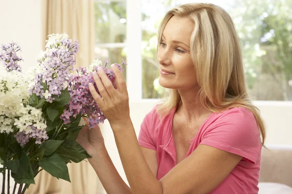 Kadın evde çiçek düzenliyor — Stok fotoğraf