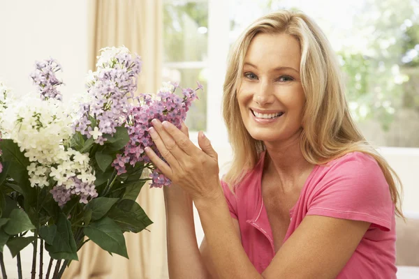 Žena doma zdobili květinami — Stock fotografie