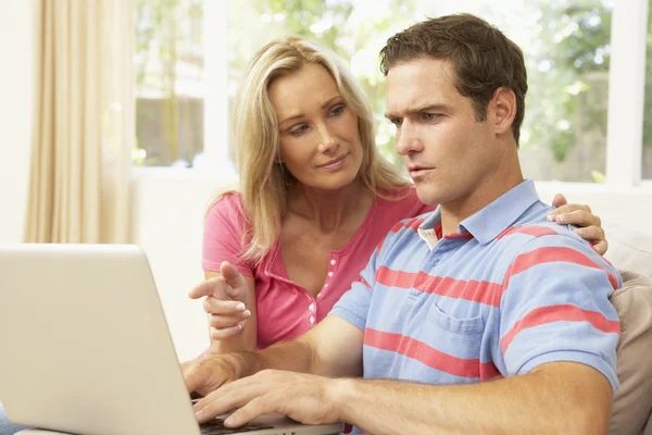 Unga par använder laptop hemma — Stockfoto