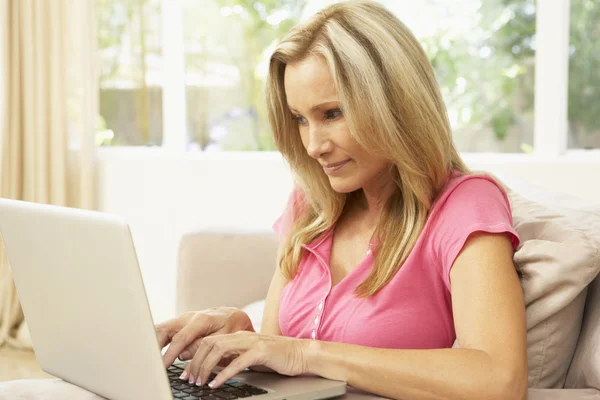 Mujer joven usando el ordenador portátil en casa — Foto de Stock
