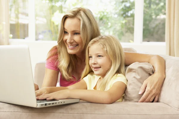 Madre e hija usando el ordenador portátil en casa —  Fotos de Stock