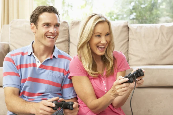 Młoda para gry komputerowe na kanapie w domu — Zdjęcie stockowe