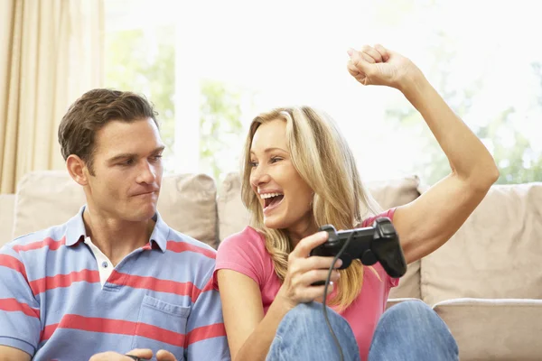 Ungt par spelar dataspel på soffan hemma — Stockfoto