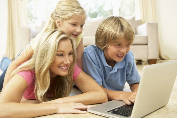 Matka i dzieci korzysta z laptopa w domu — Zdjęcie stockowe