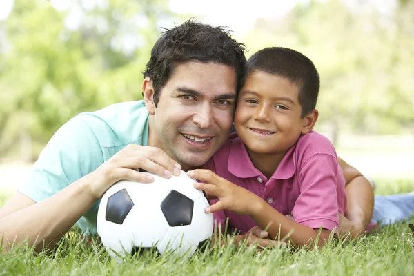 Far och son i park med fotboll Royaltyfria Stockfoton