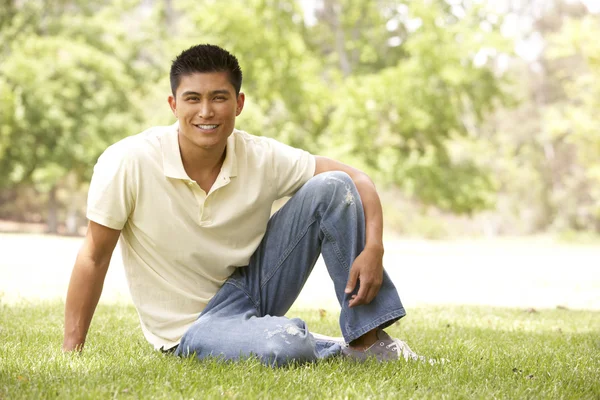 Portrait Of Young Man Sitting In Park Stock Photo