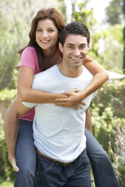 Young Man Giving Woman Piggyback Outdoors Royalty Free Stock Images