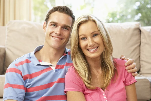 Young Couple Relaxing On Sofa At Home Royalty Free Stock Photos