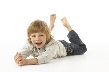 Young Boy Lying On Stomach In Studio clipart