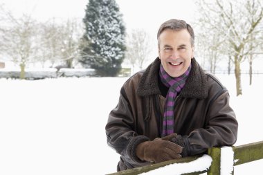 Senior Man Standing Outside In Snowy Landscape clipart