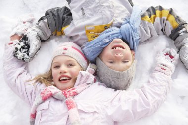 Children Laying On Ground Making Snow Angel clipart