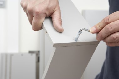 Close Up Of Man Assembling Flat Pack Furniture clipart