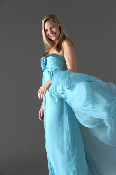 Estúdio de comprimento total tiro de mulher jovem em vestido de noite azul — Fotografia de Stock