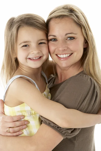 Studio portret van moeder knuffelen jonge dochter — Stockfoto