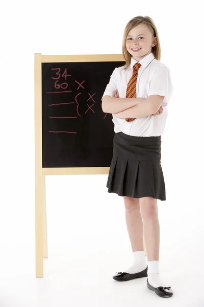 Doordachte vrouwelijke student dragen uniform naast schoolbord — Stockfoto