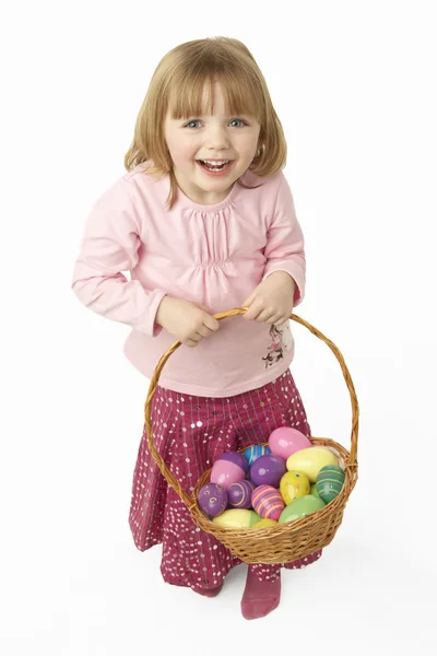 Menina jovem transportando cesta preenchida com ovos de Páscoa — Fotografia de Stock