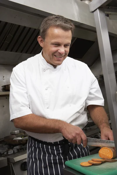 Мужской шеф-повар готовит овощи на кухне ресторана — стоковое фото