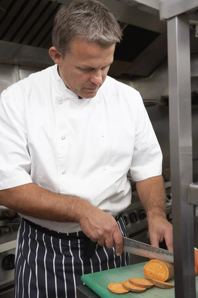 Mužský šéfkuchař připravuje zelenina v kuchyni restaurace — Stock fotografie