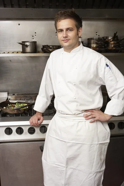 Chef masculino em pé ao lado do fogão na cozinha do restaurante — Fotografia de Stock