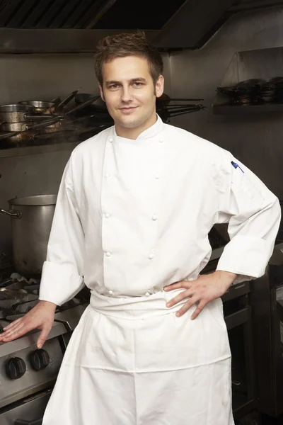 レストランのキッチンでの調理の隣に立っている男性のシェフ — ストック写真