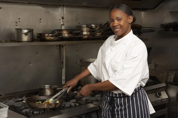 Ženské šéfkuchař připravuje jídlo na sporáku v kuchyni restaurace — Stock fotografie