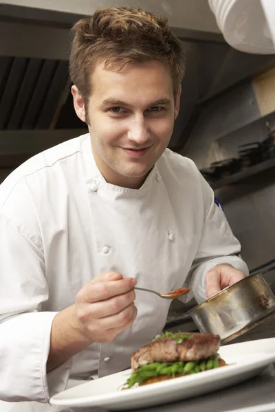 Chef Adicionando molho ao prato na cozinha do restaurante — Fotografia de Stock