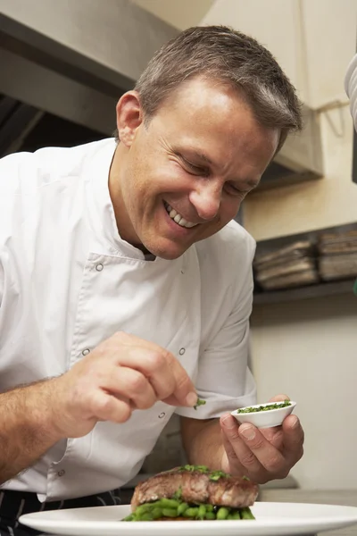 Chef kruiden toe te voegen om schotel in restaurant keuken — Stockfoto