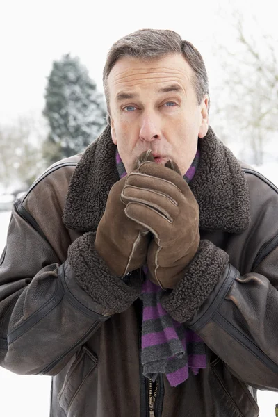 高级的男子站在外面 在雪域景观变暖的手中 — 图库照片