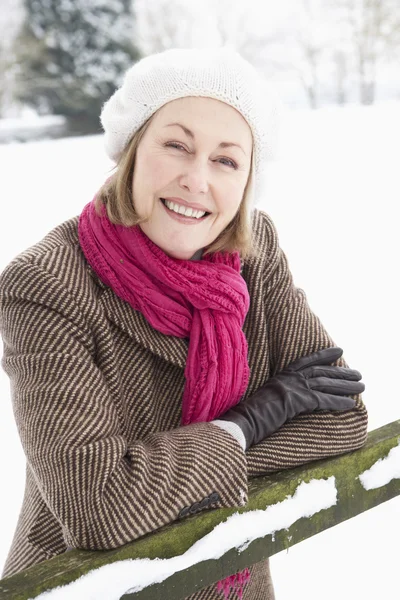 Seniorin steht draußen in verschneiter Landschaft — Stockfoto