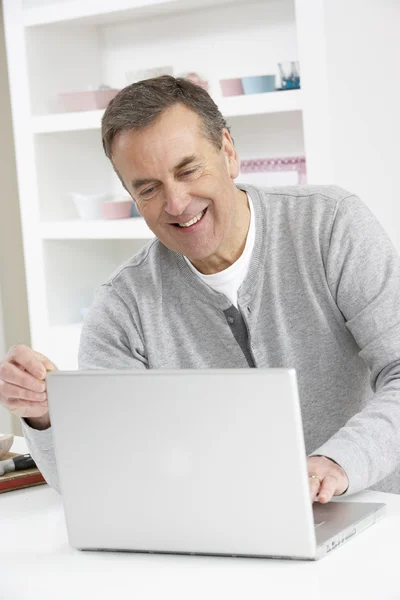 Uomo anziano che utilizza il computer portatile a casa — Foto Stock