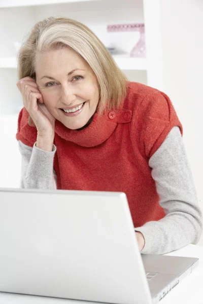 在家里使用笔记本电脑的老年妇女 — 图库照片