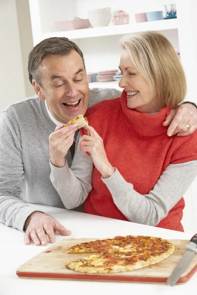 年配のカップル共有キッチンで持ち帰り用のピザ — ストック写真