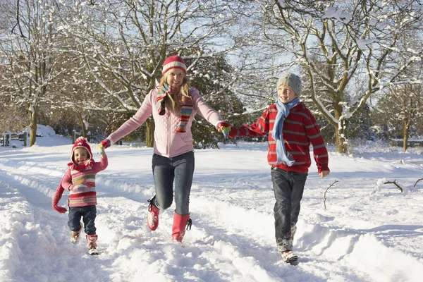 Мати прогулянки з дітей через сніжний пейзаж — стокове фото