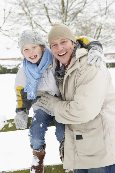 Pai e filho de pé fora na paisagem nevada — Fotografia de Stock