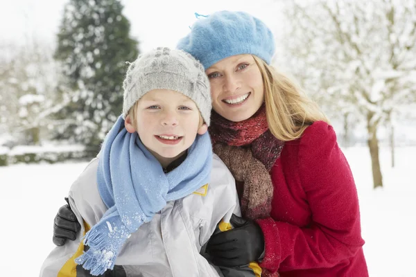 Anne ve oğlu dışında karlı manzarada duran — Stok fotoğraf