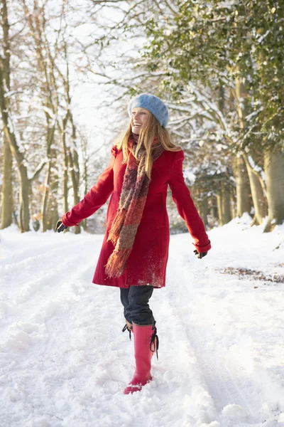 눈 덮인 숲을 통해 걷는 여자 — 스톡 사진