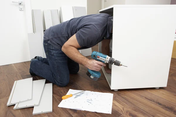 フラットパック家具を組み立てる男 — ストック写真