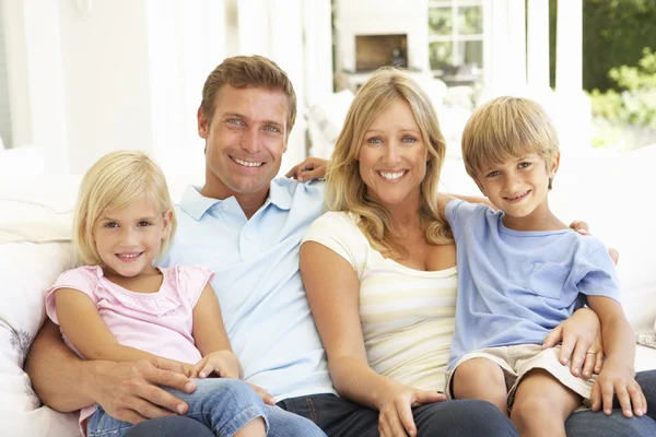 Familie Sitzt Lächelnd Wohnzimmer — Stockfoto