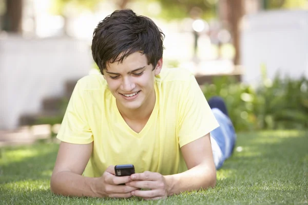 Nastoletni Chłopiec Parku Przy Użyciu Telefonu Komórkowego — Zdjęcie stockowe