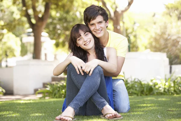Portret romantyczny nastolatek para siedzi w parku — Zdjęcie stockowe