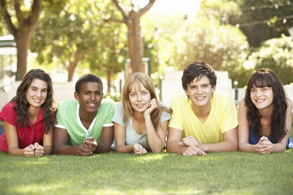 Skupina teenagerů na žaludky v parku — Stock fotografie