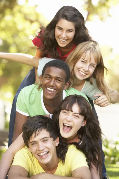 Grupo de adolescentes amontonados en el parque — Foto de Stock