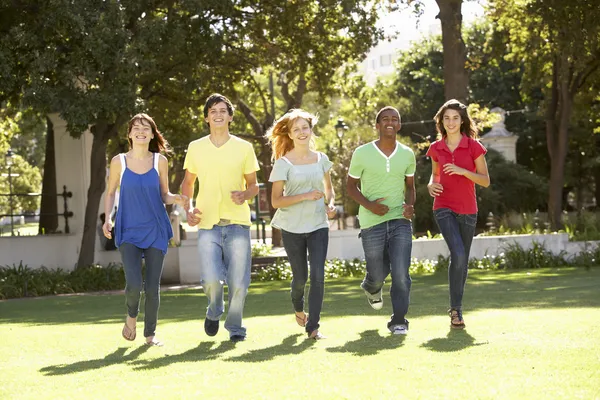 Grupp tonåringar löper genom parken — Stockfoto