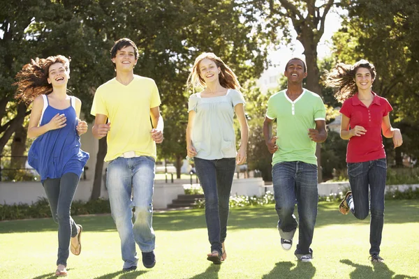 Grupa nastolatków uruchomiony przez park — Zdjęcie stockowe