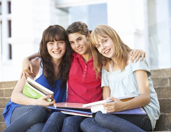 Grupp tonåriga kvinnliga vänner sitter på college steg utanför — Stockfoto